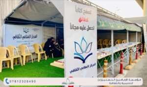 لافتة كبيرة كُتب عليها تصفّح كتاباً لدقائق تحصل عليه مجاناً أمام خيمة كتب للمركز الإسلامي الثقافي | A large banner reading 'browse a book for minutes and get it free' in front of the Islamic Cultural Center's book tent