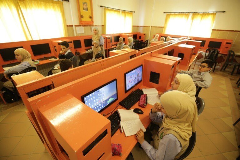طلاب يدرسون في مختبر حاسوب مدرسي باستخدام أجهزة الكمبيوتر داخل ثانوية البشائر | Students studying in a school computer lab using desktop computers at Thanaouiya Al Bashayer