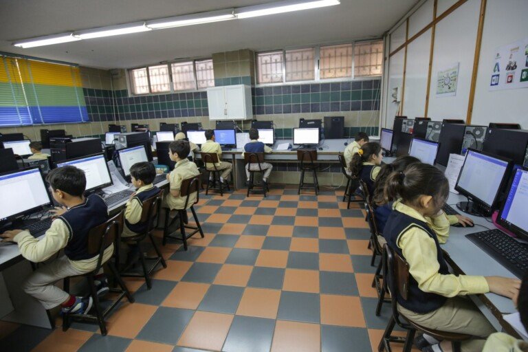 طلاب يستخدمون أجهزة الحاسوب داخل مختبر مدرسي مجهز في ثانوية المجتبى | Students using computers in a well-equipped school computer lab at Al Mujtaba School