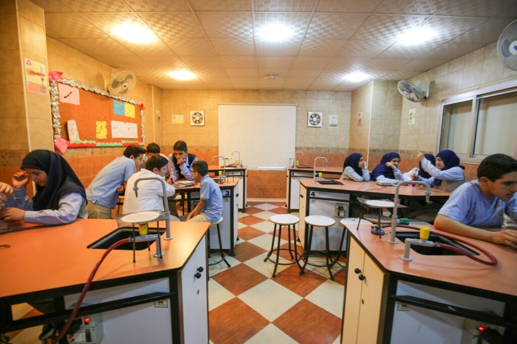 طلاب يشاركون في أنشطة وتجارب علمية داخل مختبر علوم مدرسي مجهز | Students engaging in science experiments inside a well-equipped school science laboratory