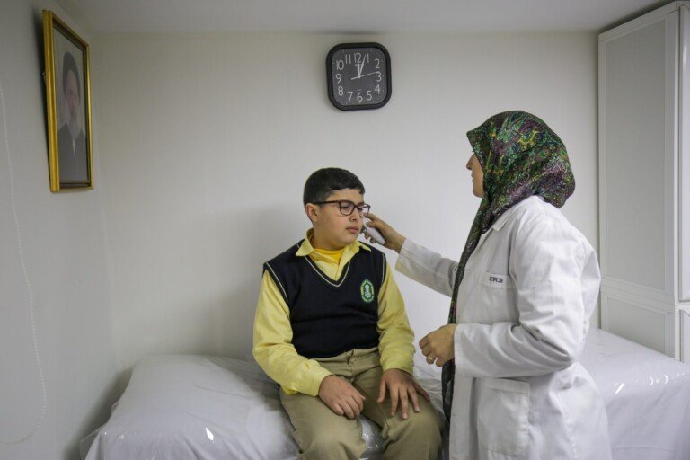 طبيبة تقوم بفحص طالب داخل غرفة طبية مدرسية في ثانوية المجتبى | Doctor examining a student in a school medical room at Al Mujtaba School