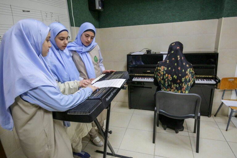 طالبات يتعلمن العزف على الآلات الموسيقية في مختبر الموسيقى في ثانوية الكوثر في لبنان | Female students learning to play musical instruments in the music lab at Thanaouiya Al Kawthar in Lebanon