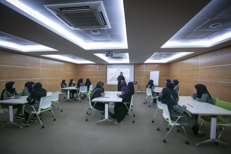 طالبات يتابعن عرضاً مرئياً في قاعة تدريب حديثة بدار الصادق | Students following a visual presentation in a modern training hall at Dar Al-Sadiq