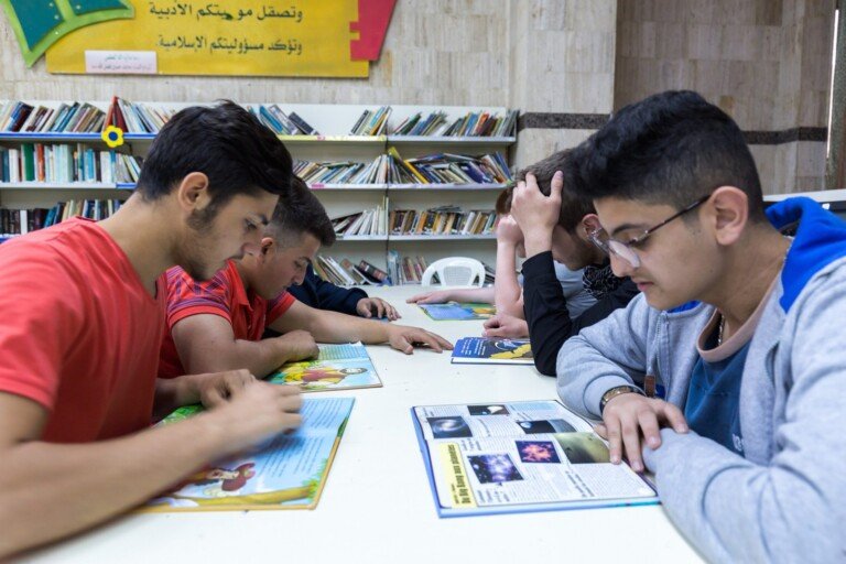 طلاب يتصفحون كتباً ومجلات علمية في مكتبة معهد علي الأكبر المهني | Students browsing science books and magazines at the library of Ali Al-Akbar Vocational Institute