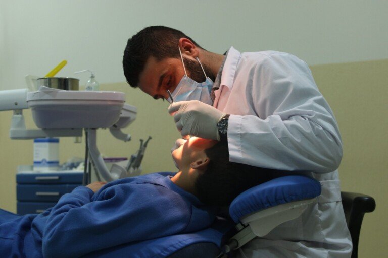 طبيب يعالج طفلاً داخل عيادة طبية باستخدام أدوات الأسنان | A doctor treating a child in a dental clinic using dental instruments