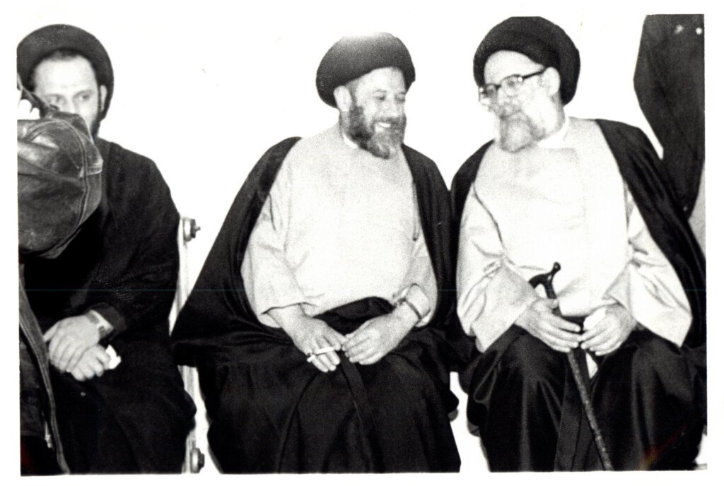 صورة أرشيفية بالأبيض والأسود لمؤسس جمعية المبرات مع علماء دين في جلسة حديث | A black-and-white archival photo of the Al-Mabarrat founder in conversation with religious scholars