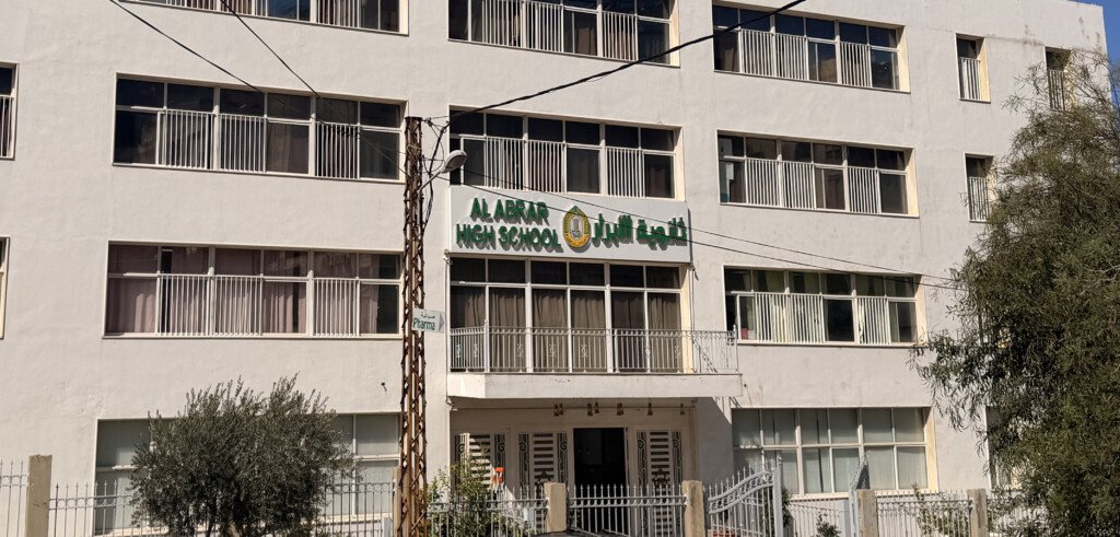 مبنى ثانوية الأبرار الأبيض تعلوه لافتة المدرسة | The white building of Al-Abrar High School with the school sign on its facade